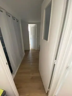 a hallway with white walls and a wooden floor at Ajaccio centre bord de mer T3 in Ajaccio