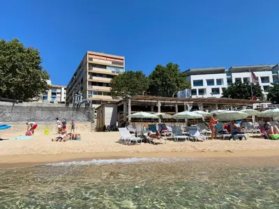 people on a beach with chairs and umbrellas at Ajaccio centre bord de mer T3 in Ajaccio