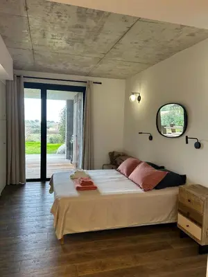 a bedroom with a large bed and a large window at A0 Magnifique Appt 6 personnes Lofts de St Lucie in Zonza