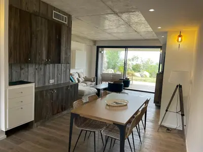 a living room with a table and a couch at A0 Magnifique Appt 6 personnes Lofts de St Lucie in Zonza