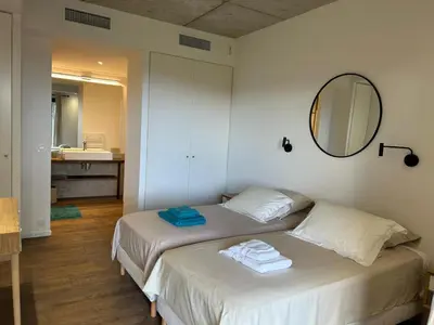 a bedroom with a bed with a mirror and a sink at A0 Magnifique Appt 6 personnes Lofts de St Lucie in Zonza
