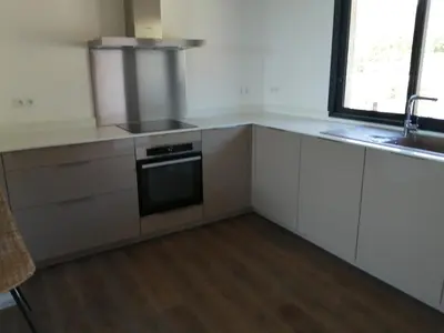 a kitchen with white cabinets and a sink and a stove at A0 Magnifique Appt 6 personnes Lofts de St Lucie in Zonza