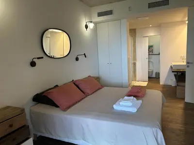 a bedroom with a bed with a mirror and a sink at A0 Magnifique Appt 6 personnes Lofts de St Lucie in Zonza