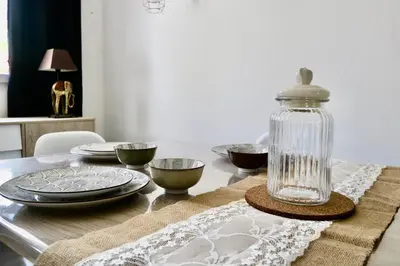 a table with plates and a glass jar on it at Gîtes Terra di a Bravona in Linguizzetta