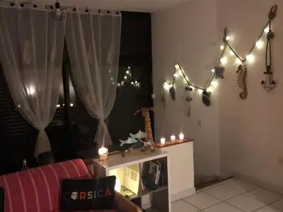 a living room with candles and lights on a window at 2026 - grand studio avec piscine et plage à 50 m in San-Nicolao
