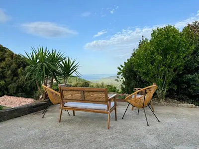 two chairs and a table on a patio at Maison à la campagne. in Sollacaro