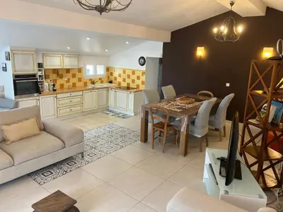 a kitchen and living room with a table and chairs at Maison à la campagne. in Sollacaro