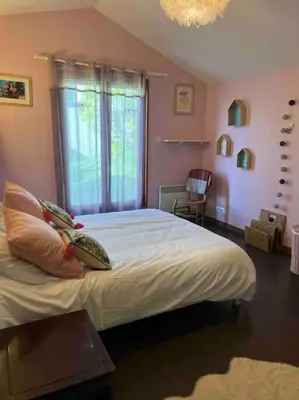 a bedroom with a large white bed with a window at Maison à la campagne. in Sollacaro