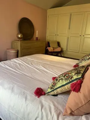 a bedroom with a white bed with two pillows on it at Maison à la campagne. in Sollacaro