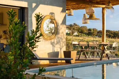 a swimming pool with a chair next to a house at Villa calme avec piscine chauffée - 6 personnes - Figari proche Porto-Vecchio et Bonifacio in Figari