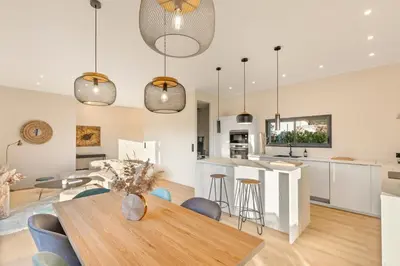 a kitchen and living room with a wooden table and chairs at Villa calme avec piscine chauffée - 6 personnes - Figari proche Porto-Vecchio et Bonifacio in Figari