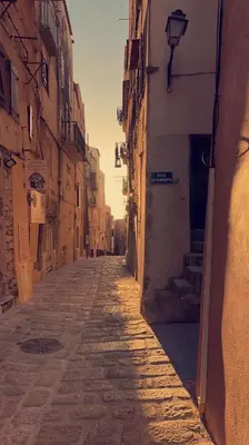an alley way with a building and the sun setting at Villa calme avec piscine chauffée - 6 personnes - Figari proche Porto-Vecchio et Bonifacio in Figari