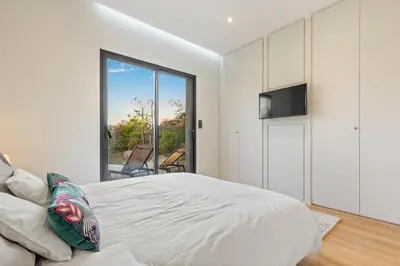 a bedroom with a bed and a large window at Villa calme avec piscine chauffée - 6 personnes - Figari proche Porto-Vecchio et Bonifacio in Figari