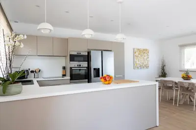 a kitchen with white cabinets and a white counter top at Villa Cargèse in Cargèse