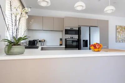 a kitchen with white cabinets and a bowl of fruit on a counter at Villa Cargèse in Cargèse