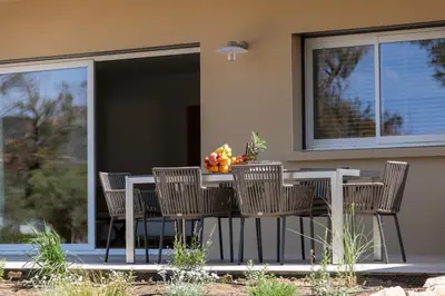 a table with chairs and a bowl of fruit on it at Villa Cargèse in Cargèse