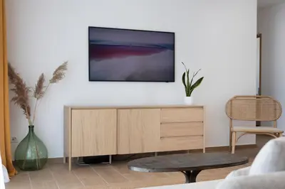 a living room with a tv on a white wall at Villa Cargèse in Cargèse