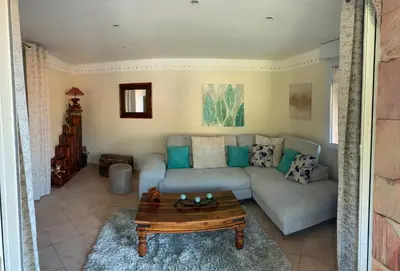 a living room with a couch and a table at Maison de village tout confort in Eccica-Suarella