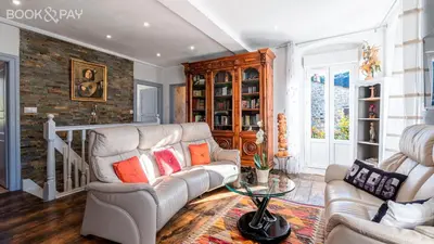 a living room with a couch and a table at Maison de village tout confort in Eccica-Suarella