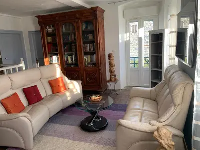 a living room with two white couches and a table at Maison de village tout confort in Eccica-Suarella