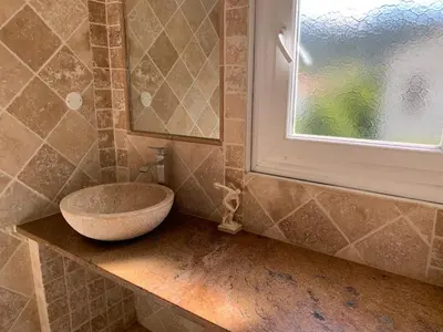 a bathroom with a sink on a counter with a window at Maison de village tout confort in Eccica-Suarella