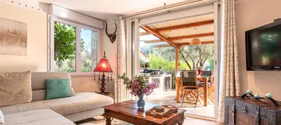a living room with a couch and a tv and a table at Maison de village tout confort in Eccica-Suarella