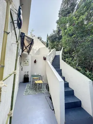 a staircase leading up to a house with a table at T2 entre Mer et Montagnes in Porto-Vecchio