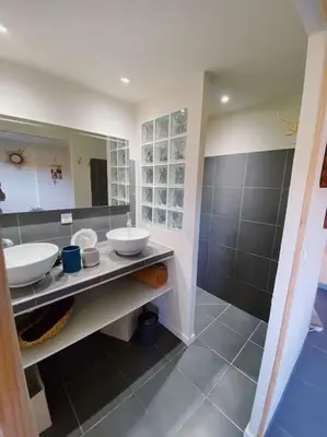 a bathroom with two sinks and a large mirror at T2 entre Mer et Montagnes in Porto-Vecchio