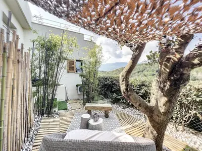 a patio with a couch and a tree at T2 entre Mer et Montagnes in Porto-Vecchio