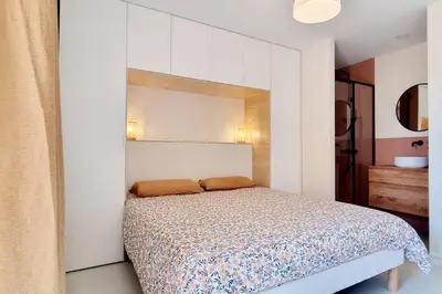 a bedroom with a bed with a mirror above it at Appartement avec terrasse au centre du village in Cargèse
