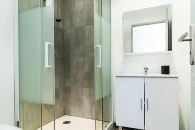 a bathroom with a shower and a sink and a mirror at Studio Charmant U Pinu, 2 personnes, 6 Kms de Porto Vecchio in Porto-Vecchio