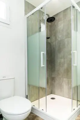 a bathroom with a toilet and a glass shower at Studio Charmant U Pinu, 2 personnes, 6 Kms de Porto Vecchio in Porto-Vecchio