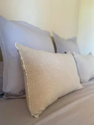 a pillow sitting on top of a bed with white pillows at Villa de charme avec piscine in Sotta