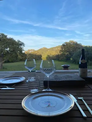 a table with two wine glasses and a bottle of wine at Villa de charme avec piscine in Sotta