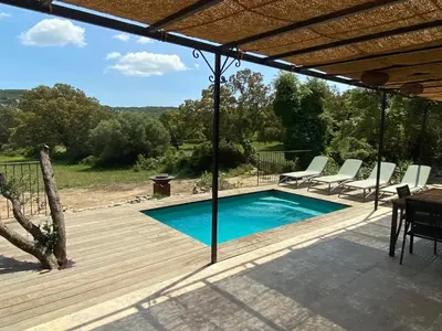 a swimming pool on a wooden deck with a table and chairs at Villa de charme avec piscine in Sotta