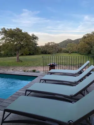 a row of lounge chairs next to a swimming pool at Villa de charme avec piscine in Sotta