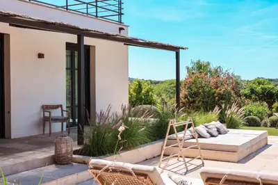 a patio of a house with a couch and chairs at Casa Nessa Di Pinarello in Sainte-Lucie de Porto-Vecchio