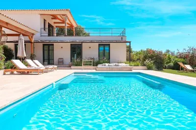 a villa with a swimming pool in front of a house at Casa Nessa Di Pinarello in Sainte-Lucie de Porto-Vecchio