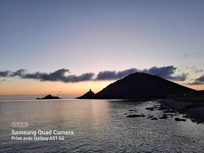 a sunset over a body of water with a mountain at Super appartement vue Sanguinaires in Ajaccio