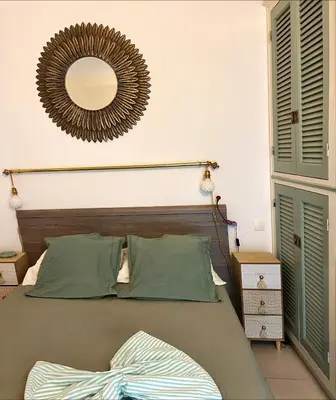 a bedroom with a bed with a mirror on the wall at Super appartement vue Sanguinaires in Ajaccio