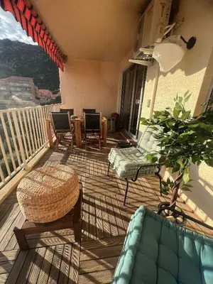 a porch with a couch and chairs on a balcony at Super appartement vue Sanguinaires in Ajaccio