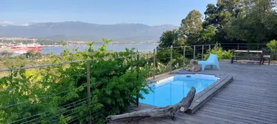 a small swimming pool on a wooden deck with a bench at La baie des anges in Porto-Vecchio