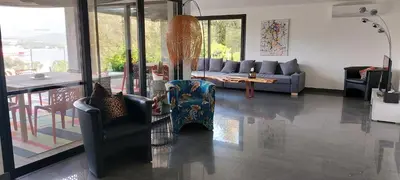 a living room with a couch and chairs and a table at La baie des anges in Porto-Vecchio