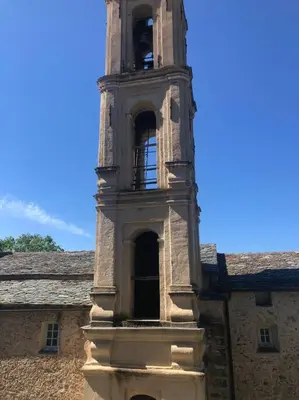 a building with a clock tower on top of it at Duplex au Village in Tox
