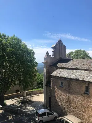 a white car parked next to a stone building at Duplex au Village in Tox
