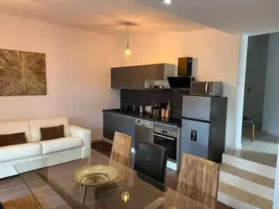 a living room with a table and a kitchen at T3 avec spa, hyper centre, port in Porto-Vecchio