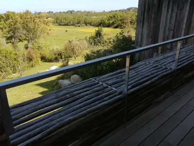 a bench on a deck with a view of a field at A1 Magnifique appt 6 personnes Lofts de Ste Lucie in Zonza