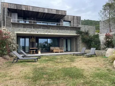 a stone house with two chairs and a table at A1 Magnifique appt 6 personnes Lofts de Ste Lucie in Zonza