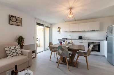 a kitchen and living room with a table and a couch at Kallistea - Appartement avec vue mer in Porticcio