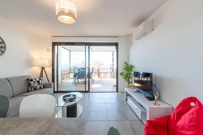a living room with a couch and a tv at Nepita in Porticcio